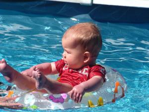 a baby in the water in a swimming pool at Arrow Motel Apartments in Nelson