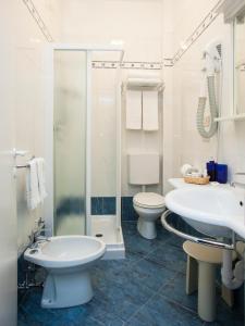 ein Bad mit einem Waschbecken, einem WC und einer Dusche in der Unterkunft Hotel Lilia in Lido di Jesolo