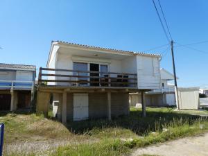 una vecchia casa con portico e balcone di UN CHALET EN BOIS A LA PLAGE a Gruissan