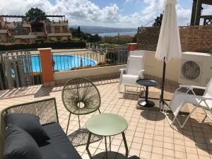 a patio with chairs and a table and an umbrella at 35G Borgonovo in Pizzo
