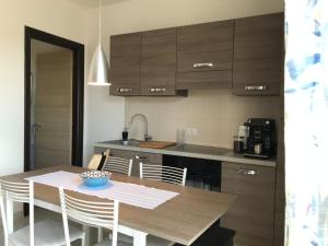a kitchen with a wooden table with chairs and a table and a kitchen with at 35G Borgonovo in Pizzo