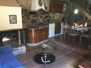 a kitchen and living room with a couch and a table at CASA RURAL BIERZO ENCANTADO in Valle de Finolledo +22 photos