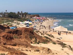 a group of people on a beach near the ocean at Caravans through the nature in Mikhmoret