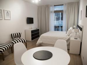 Studio Esmeralda في بوينس آيرس: غرفة نوم بسرير وطاولة وكراسي