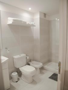 a white bathroom with a toilet and a shower at Studio Esmeralda in Buenos Aires