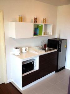 a kitchen with a sink and a microwave at BanKunKoey A501 2 Bed Condo Mountain view Near Blue Ports 300m from the Beach in Hua Hin
