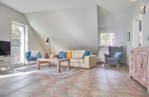 ein Wohnzimmer mit einem Sofa, einem Tisch und Stühlen in der Unterkunft Sommerhaus Thiessow in Thiessow