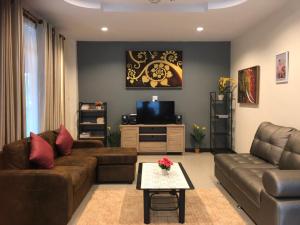 sala de estar con sofá y TV en De rae nong en Ranong