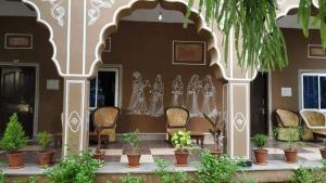 a building with a group of chairs and potted plants at Pushkar Vela Resort in Pushkar