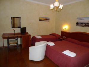 a hotel room with two beds and a desk at B&B Il Nido in Tropea