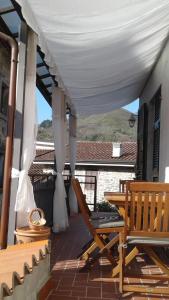 una veranda con baldacchino bianco e sedia di Il Giardino Nascosto a Codiponte