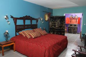 a bedroom with a red bed and blue walls at Mas de la Chapelle in Arles