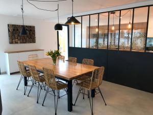 Domaine de la pointe Quiberon في كويبيرون: غرفة طعام مع طاولة وكراسي خشبية
