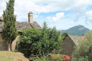 an old house with a mountain in the background at Maison de village in Ortiporio