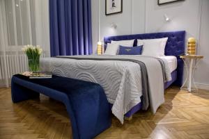 Dormitorio azul con cama grande y cabecero azul en Bentis Luxury Apartments, en Cracovia