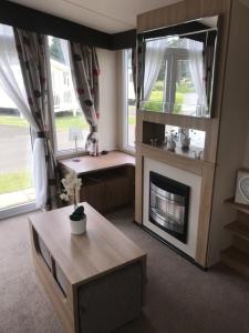 a living room with a fireplace and a table at Seton Sands in Port Seton