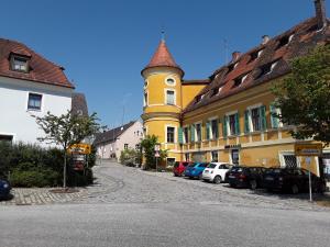 a building with a clock tower next to parked cars at Gaststätte Liebl in Wiesent
