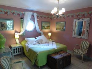 a bedroom with a green bed and a chair at Mas de la Chapelle in Arles