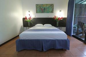 um quarto com uma cama grande num quarto com flores em Tirimbina Rainforest Lodge em Sarapiquí