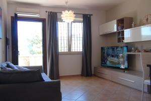 ein Wohnzimmer mit einem Sofa und einem Flachbild-TV in der Unterkunft Relax sul Lago in Genzano di Roma