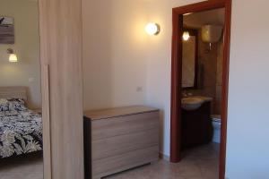 Schlafzimmer mit einem Bett, einem Waschbecken und einem Spiegel in der Unterkunft Relax sul Lago in Genzano di Roma