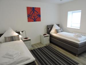 1 Schlafzimmer mit 2 Betten und einem Fenster in der Unterkunft Haus Ferienwohnungen Hubert in Saarbrücken