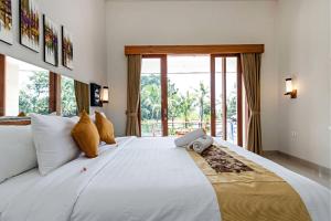 Postel nebo postele na pokoji v ubytování Indah Bali Guesthouse