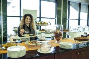 a woman sitting at a table with plates of food at Hotel Diplomat Palace in Rimini