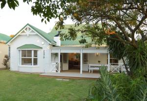 een wit huis met een veranda met een terras bij Robin 4270 in Plettenbergbaai