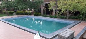 una piscina con un banco junto a una casa en Pushkar Vela Resort, en Pushkar