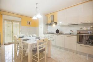 a kitchen with a table and chairs in a room at Etna Sunshine in Linguaglossa