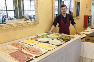 a man standing in front of a buffet of food at Hotel Diplomat Palace in Rimini