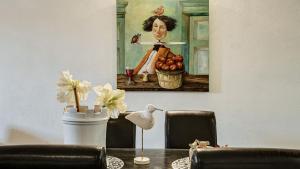una mesa con una pintura de una mujer con una cesta de fruta en La Colombaia Nel Castello, en Bracciano