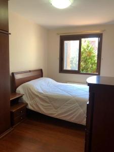 ein Schlafzimmer mit einem Bett und einem Fenster in der Unterkunft Casa no coração de gramado in Gramado
