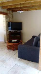 a living room with a blue couch and a coffee table at L'Hibiscus in Talais