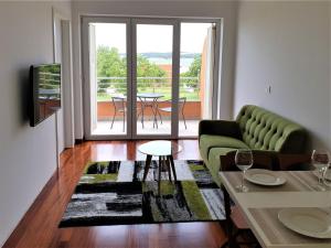 - un salon avec un canapé vert et une table dans l'établissement Apartments Aurora near beach, à Medulin