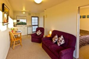 a living room with a couch and a table at Arrow Motel Apartments in Nelson