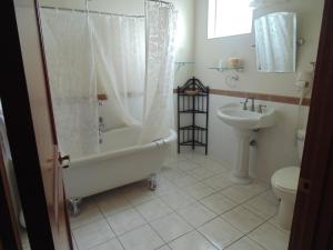 ein Badezimmer mit einer Badewanne, einem WC und einem Waschbecken in der Unterkunft Manresa Castle in Port Townsend