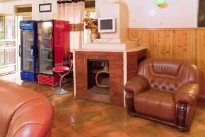 een woonkamer met een stoel en een open haard bij Capricon Executive Hotel Kabale in Kabale