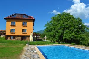 a house with a swimming pool in front of a building at Villa Aya in Smochevo