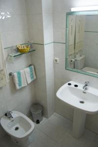 a bathroom with a sink and a toilet and a mirror at Hotel Martín Esperanza in Portonovo