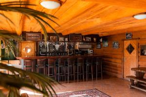 un bar con taburetes en una habitación con techos de madera en Tindioru Holiday House en Rõuge