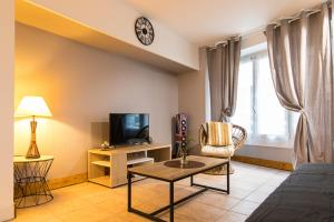 a living room with a tv and a couch and a table at COSY HOME PERIGUEUX in Périgueux