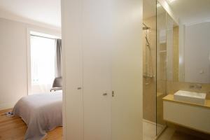 1 dormitorio con cama, ducha y lavamanos en Cosy Marques de Pombal Apartment, en Lisboa 38 fotos más