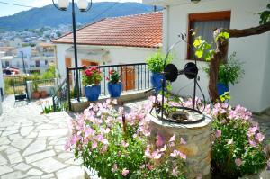 a house with a bunch of flowers in front of it at Pension Mando in Skiathos