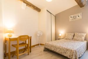 a bedroom with a bed and a desk and a chair at COSY HOME PERIGUEUX in Périgueux