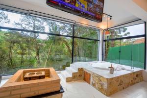 a large bathroom with a tub and a large window at Resort Magnifico in Monte Verde