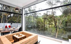 a living room with a large window and a table at Resort Magnifico in Monte Verde