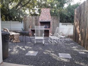 a group of chairs and a table in a backyard at Relax in Joy & Mignon for a bushveld Feeling in Bloemfontein