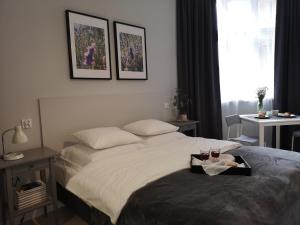 a bedroom with a bed with a tray of food on it at Glam House Apartments in Poznań